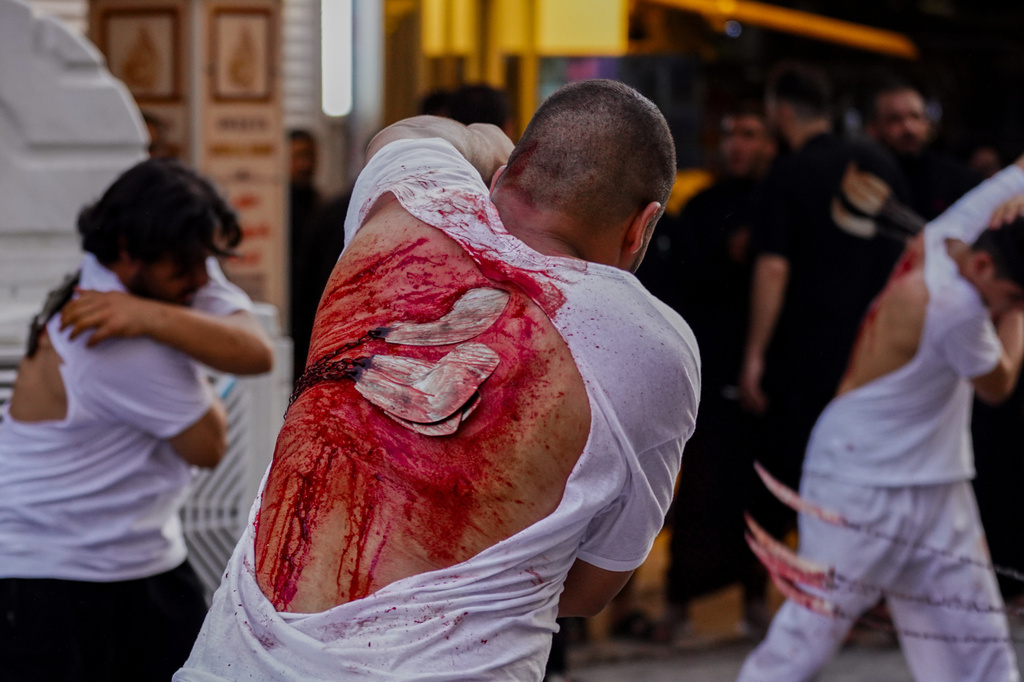 EDS NOTE: GRAPHIC CONTENT - Shiite faithful pilgrims flagellate themselves as a sign of grief for Imam Hussein during a Muharram procession, in Najaf, Iraq, Tuesday, June 23, 2026. (AP Photo/Anmar Khalil)