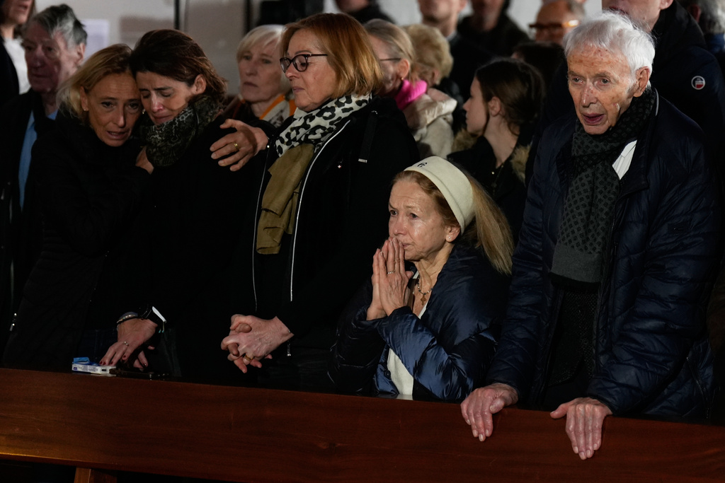 People cry during a memorial mass at the Chapelle St-Christophe in Crans-Montana, Swiss Alps, Switzerland, Sunday, Jan. 4, 2026, after a devastating fire in Le Constellation bar left dead and injured during the New Year's celebrations. (AP Photo/Baz Ratner)