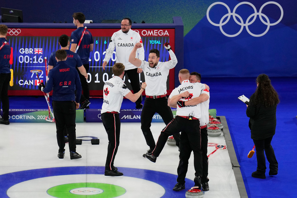 Canada's Ben Hebert, Brett Gallant, Marc Kennedy and Brad Jacobs celebrate after beating Britain in the men's curling gold medal match at the 2026 Winter Olympics, in Cortina d'Ampezzo, Italy, Saturday, Feb. 21, 2026. (AP Photo/David J. Phillip)