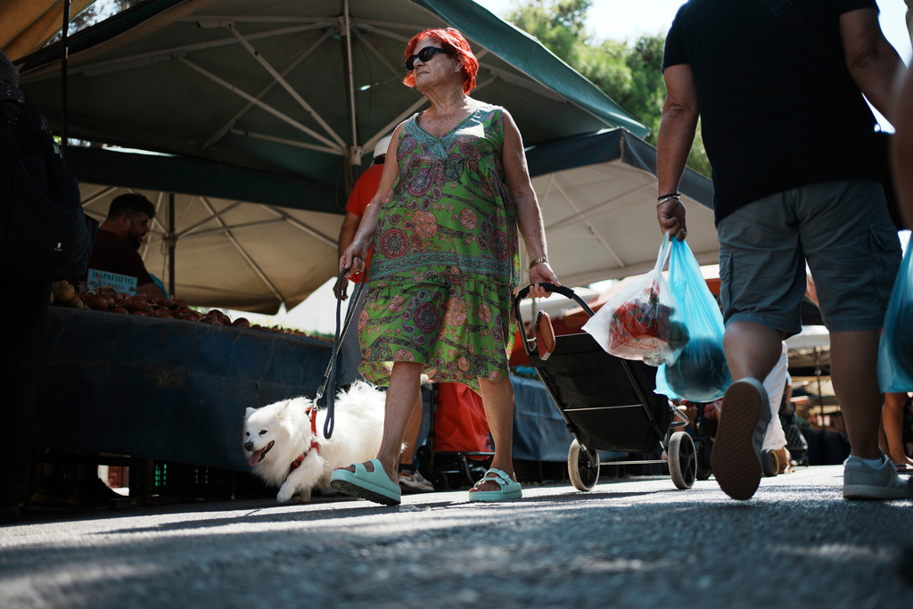 People shop at an open-air fruit and vegetable market in Athens, Greece, Friday, Sept. 5, 2025. (AP Photo/Thanassis Stavrakis)
