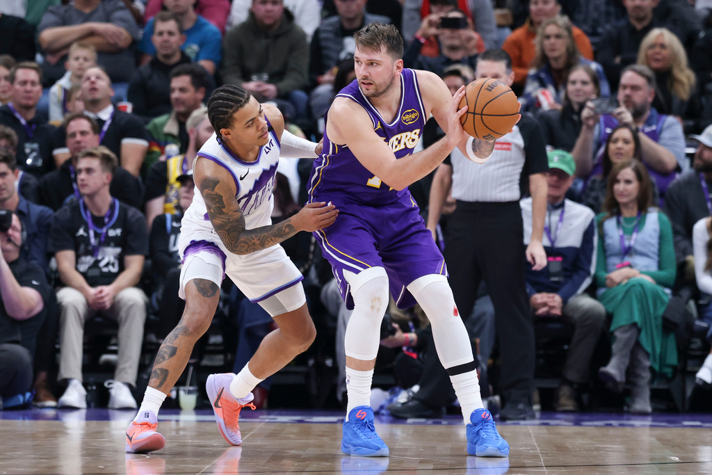 Los Angeles Lakers guard Luka Doncic (77) posts up against Utah Jazz guard Keyonte George, left, during the second half of an NBA basketball game, Thursday, Dec. 18, 2025, in Salt Lake City. (AP Photo/Rob Gray)