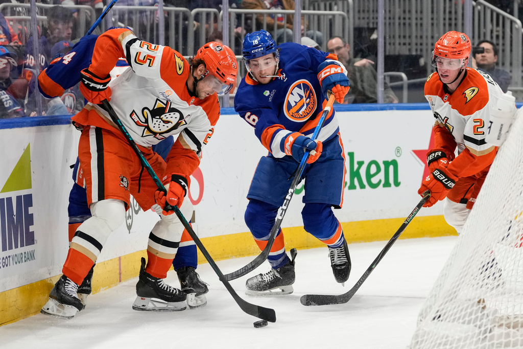 Anaheim Ducks center Ryan Poehling (25) fights for control of the puck with New York Islanders center Marc Gatcomb (16) during the second period of an NHL hockey game, Thursday, Dec. 11, 2025, in Elmont, N.Y. (AP Photo/Yuki Iwamura)