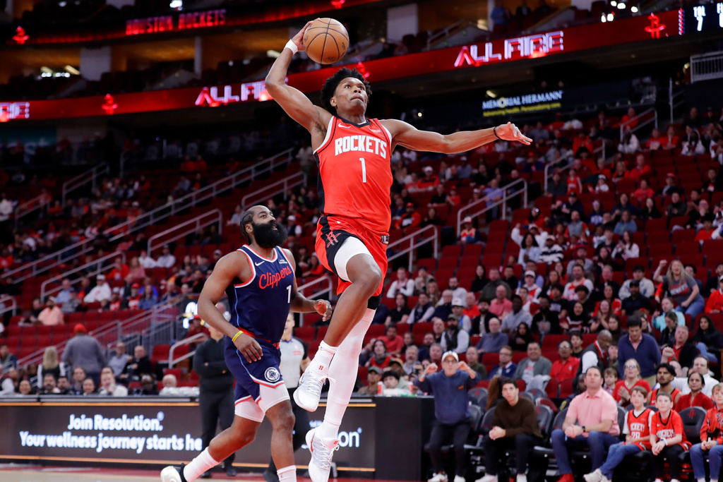 Houston Rockets guard Amen Thompson, right, goes up to dunk in front of LA Clippers guard James Harden, left, during the first half of an NBA basketball game Thursday, Dec. 11, 2025, in Houston. (AP Photo/Michael Wyke)