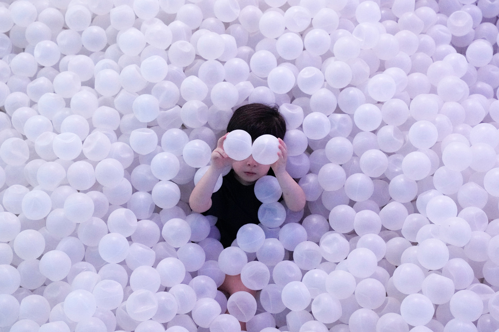 A child plays in a ball pit during an immersive exhibit at the Megapolis Outlets Center in Panama City, Tuesday, April 7, 2026. (AP Photo/Matias Delacroix)