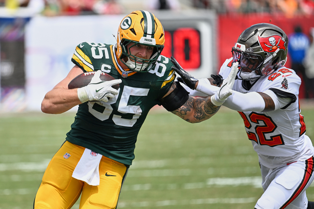 Tampa Bay Buccaneers cornerback Keionte Scott (22) grabs Green Bay Packers tight end Tucker Kraft (85) during the first half of an NFL football game in Tampa, Fla., Sunday, Oct. 4, 2026. (AP Photo/Jason Behnken)