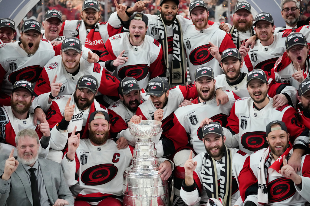 The Carolina Hurricanes pose for photos after a win over the Vegas Golden Knights in Game 6 of the NHL hockey Stanley Cup Final series, Sunday, June 14, 2026, in Las Vegas. (AP Photo/John Locher)
