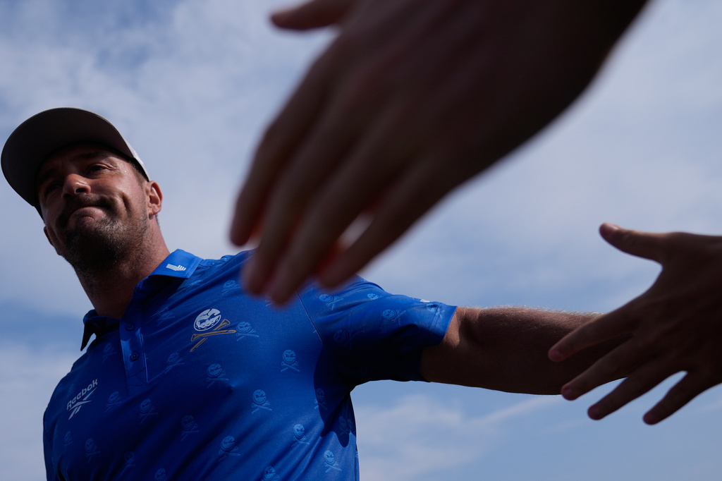 Bryson DeChambeau of the United States taps hands with spectators as he walks to the 9th tee during the second day of the British Open Golf championships at Royal Birkdale golf club, in Southport, England, Friday, July 17, 2026. (AP Photo/David Goldman)
