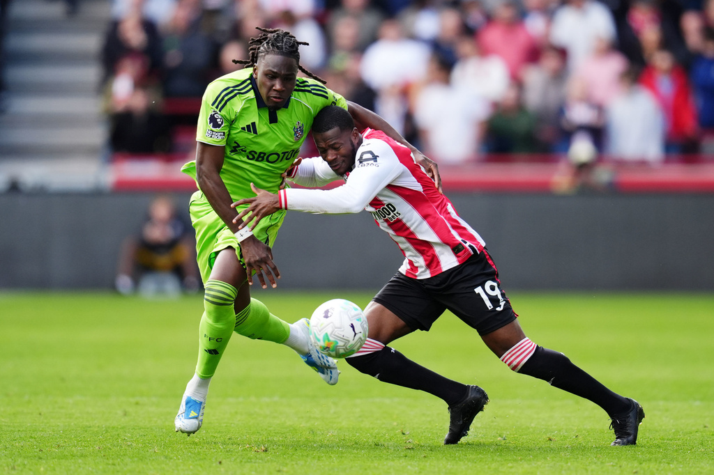 Fulham's Calvin Bassey, left, and Brentford's Dango Ouattara battle for the ball during the English Premier League soccer match between Brentford and Fulham in Brentford, England, Saturday April 18, 2026. (John Walton/PA via AP)