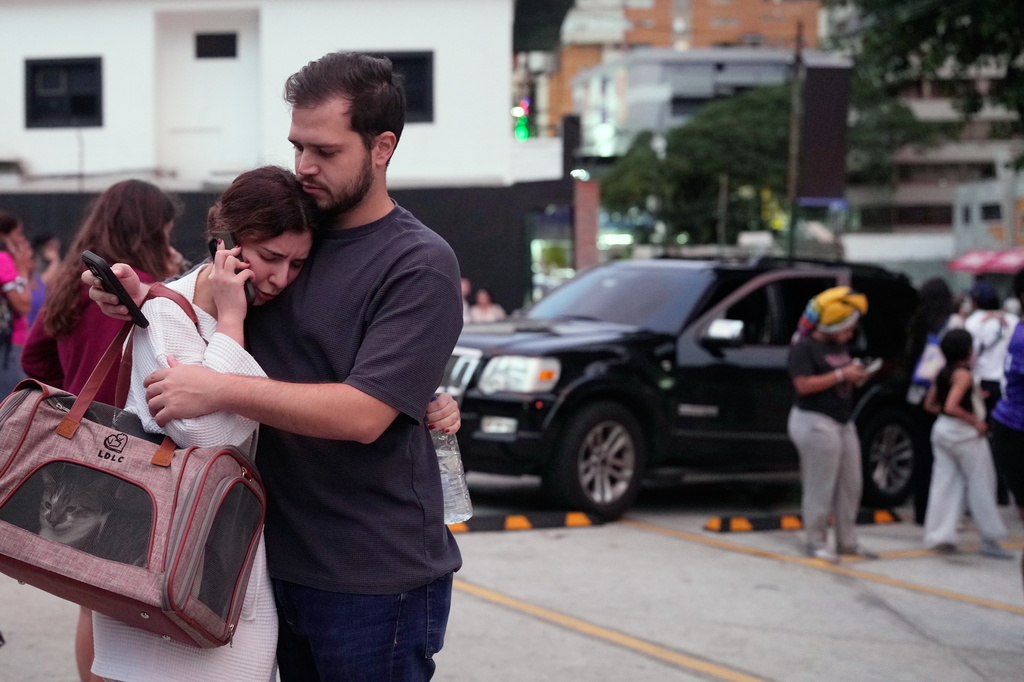 People embrace after an earthquake in Caracas, Venezuela, Wednesday, June 24, 2026. (AP Photo/Ariana Cubillos)