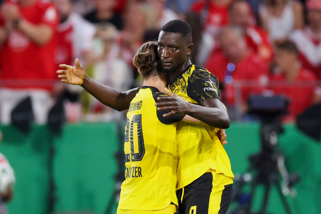 Borussia Dortmund's Serhou Guirassy, right, celebrates scoring a goal with teammate Marcel Sabitzer, during the German Cup first-round soccer match between Essen and Borussia Dortmund, at Stadion an der Hafenstrasse in Essen, Germany, Monday, Aug. 18, 2025. (Christoph Reichwein/dpa via AP)
