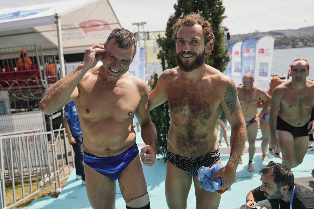 Ukrainian war veterans Pavlo Tovstyk, left, and Oleh Tserkovnyi, smile after completing a 6.5km swimming race across the Bosporus Strait, from the Asian side to the European side, in Istanbul, Turkey, Sunday, Aug. 24, 2025. (AP Photo/Khalil Hamra)