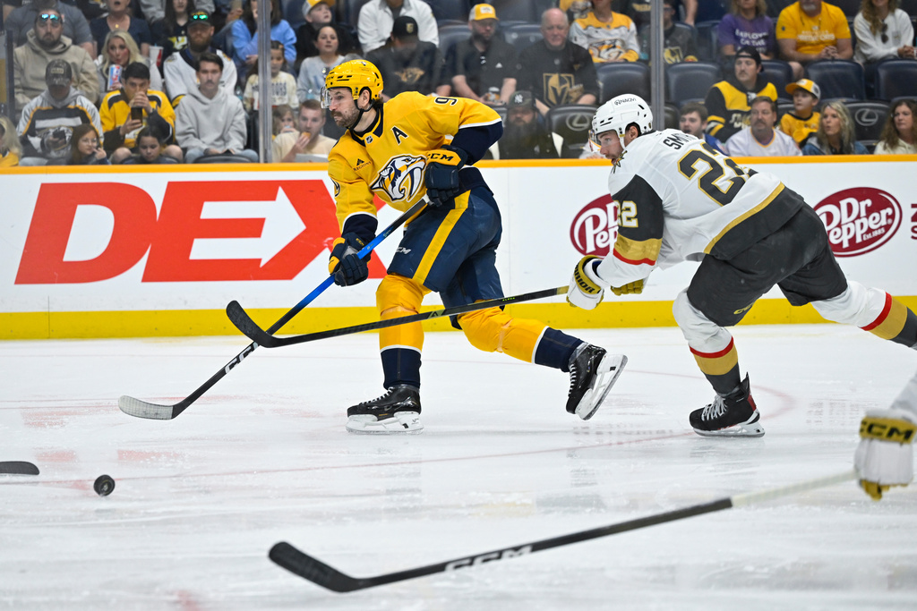 Nashville Predators left wing Filip Forsberg (9) skates with the puck in front of Vegas Golden Knights right wing Cole Smith (22) during the second period of an NHL hockey game Saturday, March 21, 2026, in Nashville, Tenn. (AP Photo/John Amis)