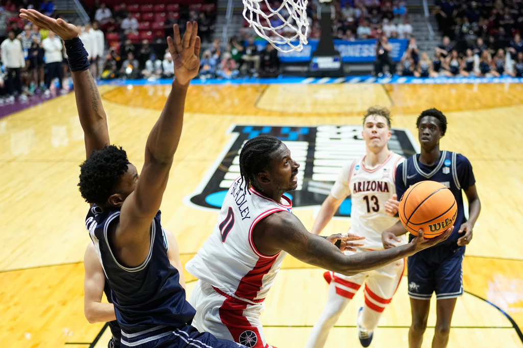 Arizona guard Jaden Bradley (0) shoots around Utah State forward Garry Clark (11) during the second half of a game in the second round of the NCAA college basketball tournament Sunday, March 22, 2026, in San Diego. (AP Photo/Mark J. Terrill)