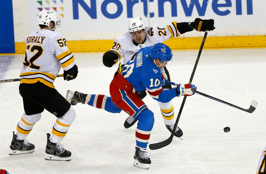 New York Rangers forward Artemi Panarin (10) skates between Boston Bruins center Sean Kuraly (52) and defenseman Henri Jokiharju (20) during the third period of an NHL hockey game Monday, Jan. 26, 2026, in New York. (AP Photo/John Munson)