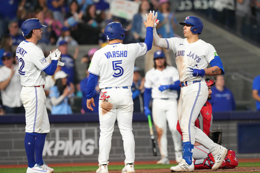 Toronto Blue Jays' Brandon Valenzuela, right, is congratulated by teammates Daulton Varsho (5) and Ernie Clement, left, as he crosses home plate after his three-run home run during fifth-inning baseball game action in Toronto, Saturday, May 9, 2026. (Chris Young/The Canadian Press via AP)