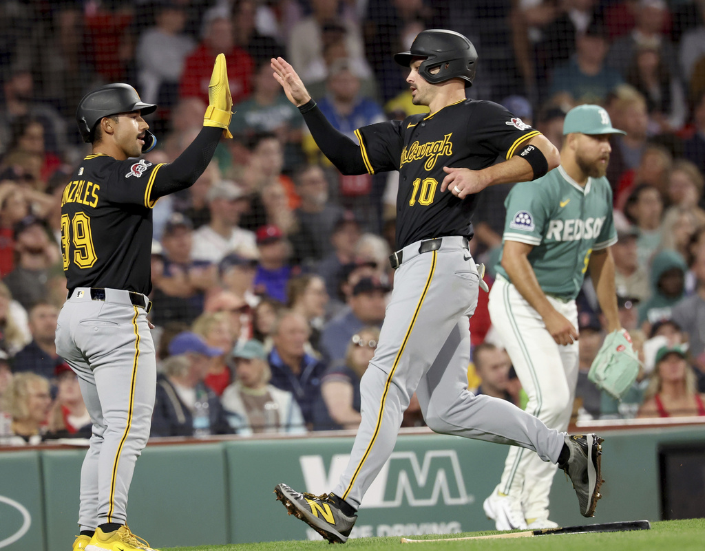 Pittsburgh Pirates Nick Gonzales (39) and Bryan Reynolds (10) high five at the plate after Reynolds hit a home run during the sixth inning of a baseball game against the Boston Red Sox, Friday, Aug. 29, 2025, in Boston. (AP Photo/Mark Stockwell)