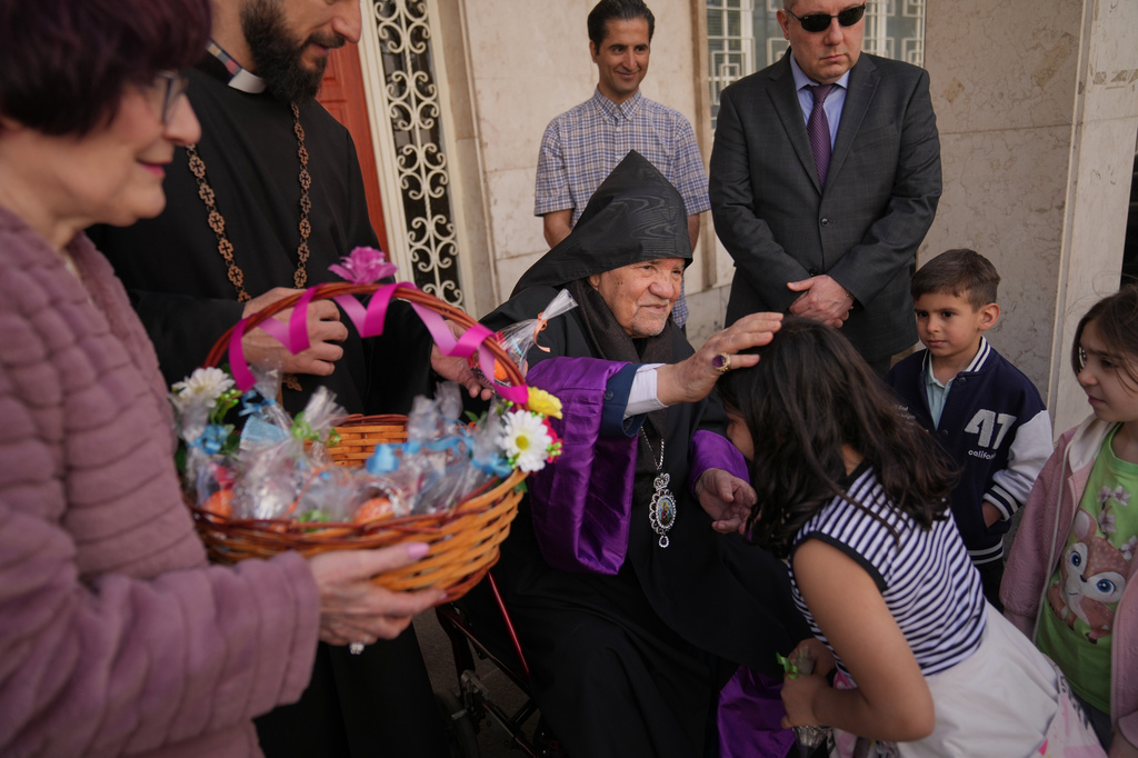 Sepuh Sargsyan, archbishop and prelate of the Armenian Apostolic Diocese of Tehran, blesses a child after Easter Sunday Mass at Saint Sarkis Cathedral in Tehran, Iran, Sunday, April 5, 2026. (AP Photo/Francisco Seco)