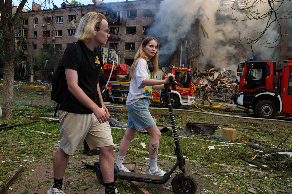People walk past a smoldering residential building destroyed by a Russian strike in the Lukianivka neighbourhood of Kyiv, Ukraine, on Sunday, May 24, 2026. (AP Photo/Evgeniy Maloletka)