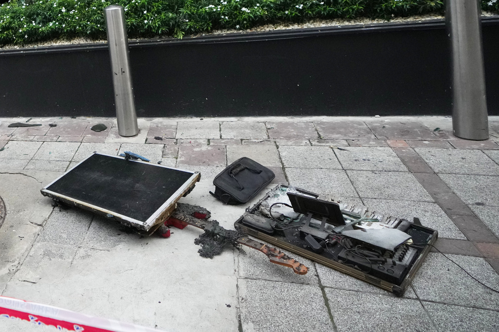 Burned musical instruments sit in front of a music bar fire in Bangkok, Thailand, Monday, July 13, 2026. (AP Photo/Sakchai Lalit)