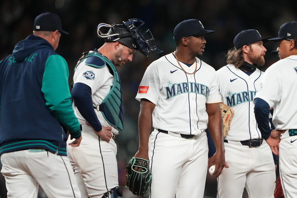 Seattle Mariners manager Dan Wilson, left, comes out to pull relief pitcher Jose Ferrer, third from left, from the seventh inning of a baseball game against the New York Yankees, Monday, March 30, 2026, in Seattle. (AP Photo/Lindsey Wasson)