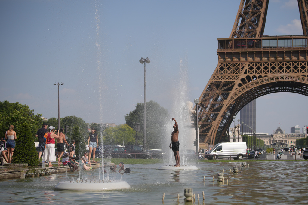 People cool off at Trocadero fountain near the Eiffel Tower during a heat wave in Paris, Wednesday, June 24, 2026. (AP Photo/Christophe Ena)