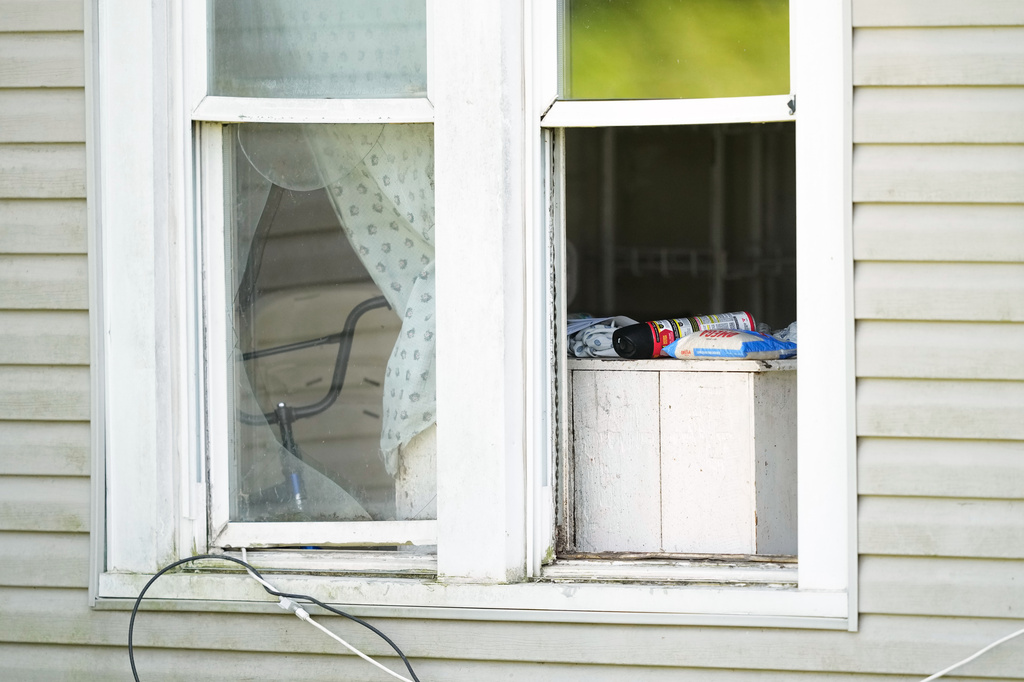 A bag of rice and a can of insect killer sit in an open window of a home where authorities say they removed 16 children and arrested four adults in Hamden, Ohio, Wednesday, July 1, 2026. (AP Photo/Carolyn Kaster)