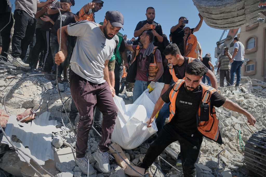 Palestinian civil defense crews carry a body from the rubble of a collapsed building that housed displaced Palestinians and was heavily damaged during the Israel-Hamas war, in Gaza City, Wednesday, Sept. 16, 2026. (AP Photo/Jehad Alshrafi)