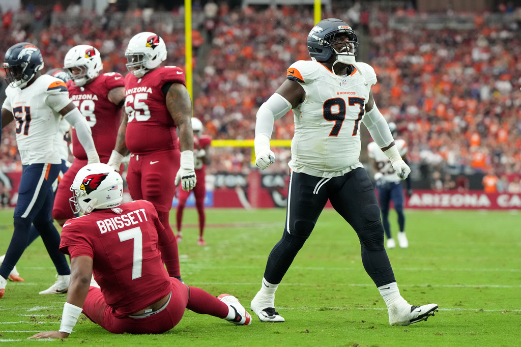 Denver Broncos defensive tackle Malcolm Roach (97) reacts to a hit on Arizona Cardinals quarterback Jacoby Brissett (7) during the first half of an NFL football game in Glendale, Ariz., Sunday, Oct. 25, 2026. (AP Photo/Rick Scuteri)