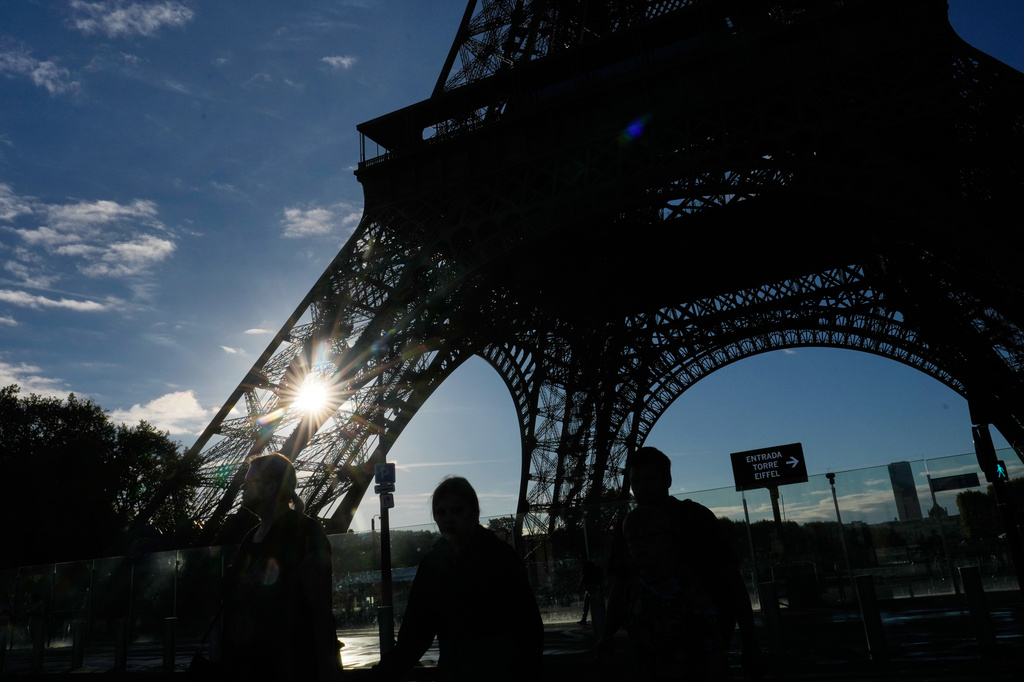 Tourists walk past the Eiffel Tower after it reopened following a one-day strike over restrictions on women during a visit by a Hindu delegation, in Paris, Tuesday, Sept. 8, 2026. (AP Photo/Christophe Ena)
