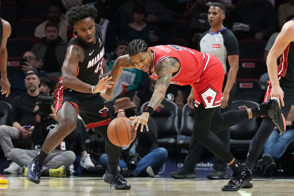Chicago Bulls forward Dalen Terry, right, loses control of the ball as Miami Heat guard Davion Mitchell (45) defends during the first half of an NBA basketball game, Sunday, Feb. 1, 2026, in Miami. (AP Photo/Lynne Sladky)