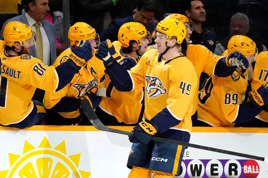Nashville Predators left wing Reid Schaefer (49) is congratulated after scoring a goal against the Calgary Flames during the first period of an NHL hockey game Tuesday, Dec. 2, 2025, in Nashville, Tenn. (AP Photo/Mark Humphrey)
