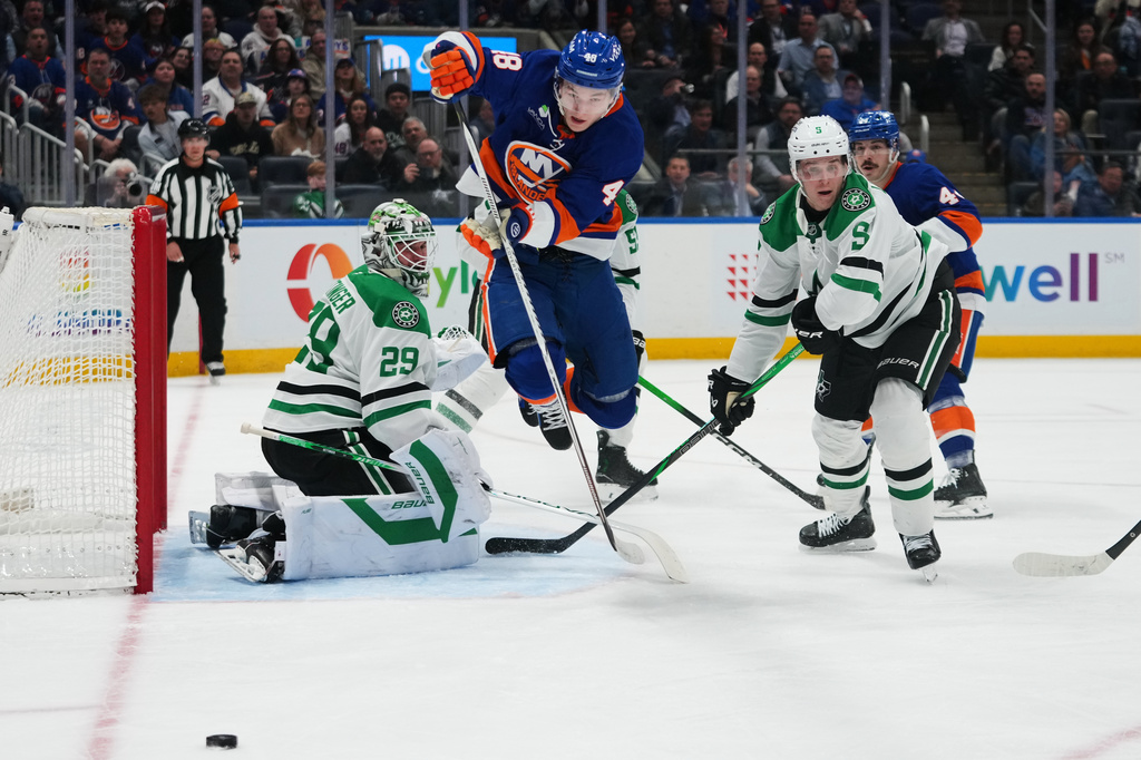 Dallas Stars goaltender Jake Oettinger (29) and Nils Lundkvist (5) protect the net from New York Islanders defenseman Matthew Schaefer (48) during the second period of an NHL hockey game Thursday, March 26, 2026, in Elmont, N.Y. (AP Photo/Frank Franklin II)