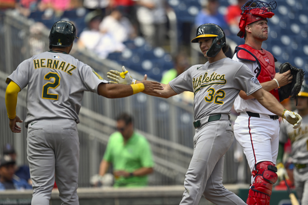 Athletics' Darell Hernaiz (2) congratulates Colby Thomas (32) for driving him in on a two-run home run during the second inning of a baseball game against the Washington Nationals, Thursday, Aug. 7, 2025, in Washington. (AP Photo/John McDonnell)