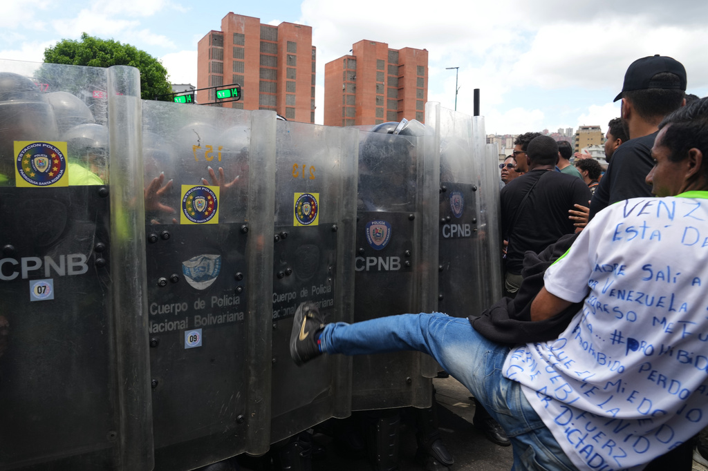 University students clash with Bolivarian National Police during a protest calling for justice after the death of Carmen Navas who died the previous day in Caracas, Venezuela, Monday, May 18, 2026, a week after the government confirmed that her missing son Victor Hugo Quero had died in custody following his arrest about a year earlier. (AP Photo/Ariana Cubillos)