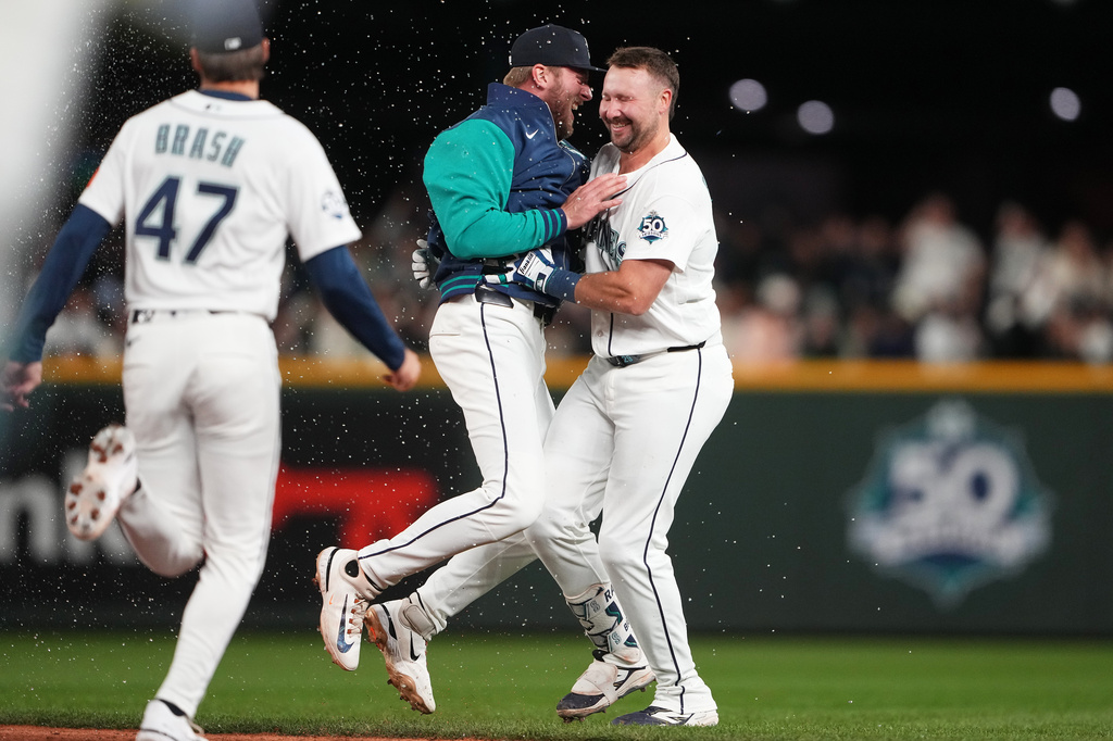 Seattle Mariners' Luke Raley celebrates with Cal Raleigh, right, after Raleigh's game-winning single against the New York Yankees after a baseball game, Monday, March 30, 2026, in Seattle. (AP Photo/Lindsey Wasson)
