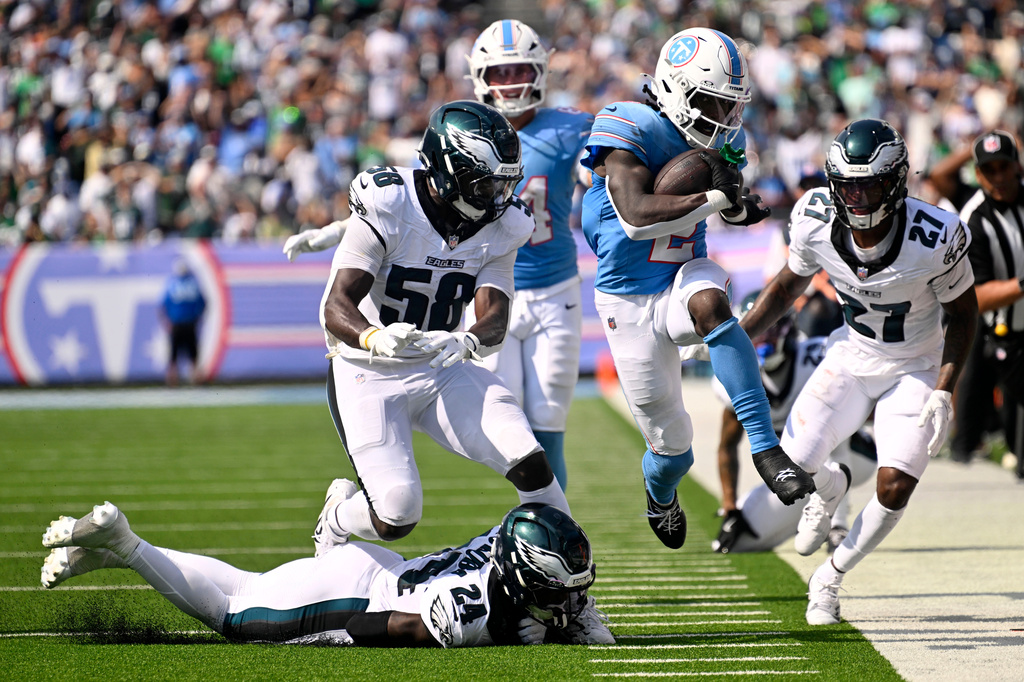 Tennessee Titans running back Tyjae Spears (2) runs from Philadelphia Eagles safety Andrew Mukuba (24), linebacker Jalyx Hunt (58) and cornerback Quinyon Mitchell (27) during the second half of an NFL football game, Sunday, Sept. 20, 2026, in Nashville, Tenn.(AP Photo/John Amis)