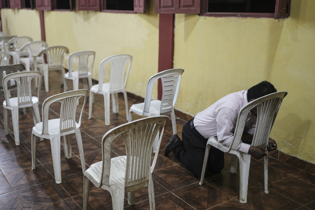 A man prays at an evangelical church in Santa Rosa, Peru, an island on the Amazon River at the center of a territorial dispute with Colombia, Sunday, Aug. 17, 2025. (AP Photo/Ivan Valencia)