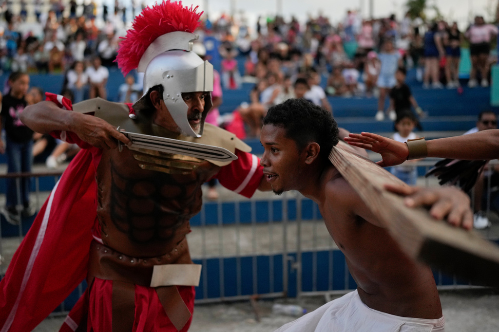 A devotee dressed as a Roman soldier assaults a penitent playing the role of one of two thieves sentenced to be crucified alongside Jesus Christ, during a Way of the Cross reenactment in Arraijan, Panama, Good Friday, April 3, 2026. (AP Photo/Matias Delacroix)