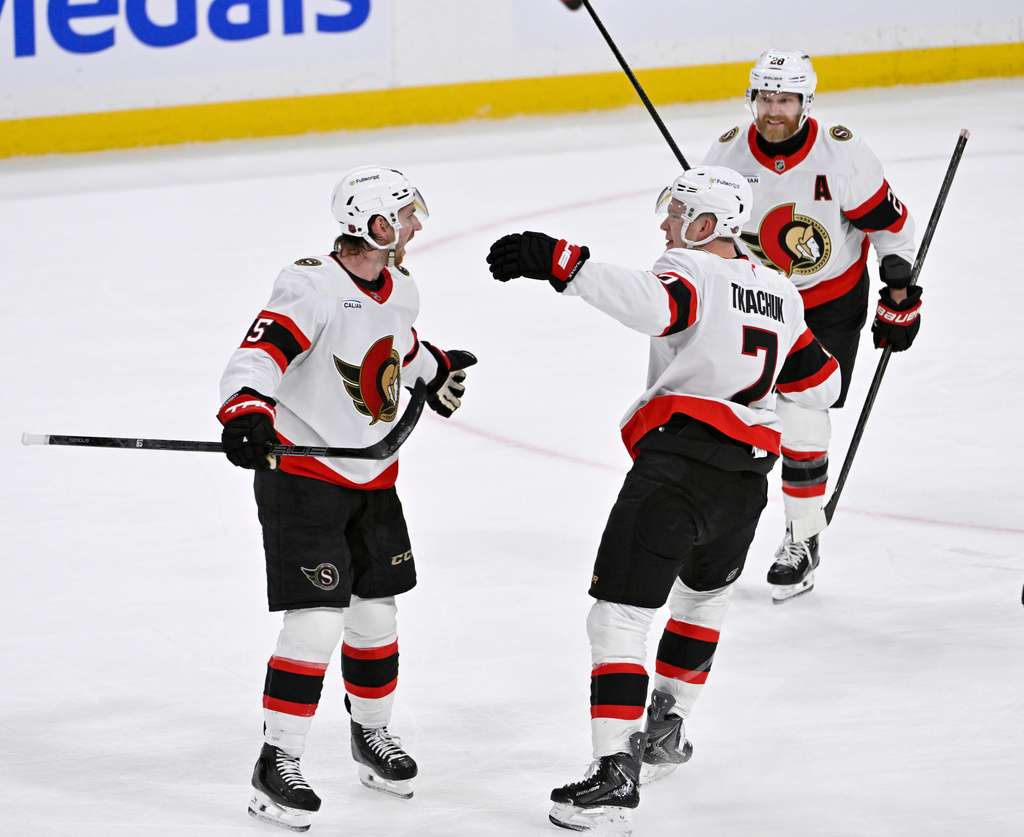 Ottawa Senators' Jake Sanderson, left, celebrates after his tying goal against the Winnipeg Jets with Brady Tkachuk (7) and Claude Giroux (28) during the third period of an NHL hockey game in Winnipeg, Manitoba, Monday, Dec. 15, 2025. (Fred Greenslade/The Canadian Press via AP)