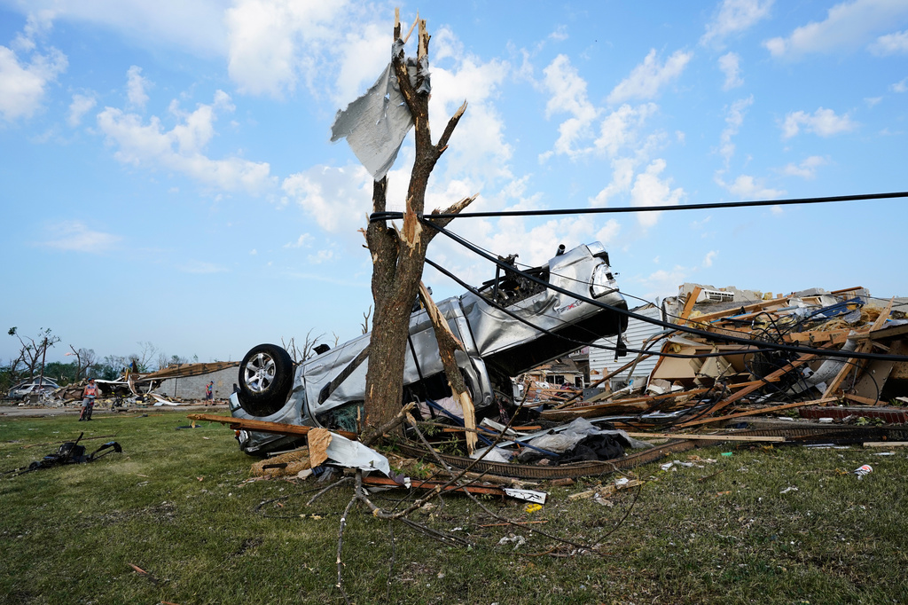 An upside down car sits tangled among power lines after a tornado struck Monday, July 27, 2026, in Menasha, Wis. (AP Photo/Kayla Wolf)