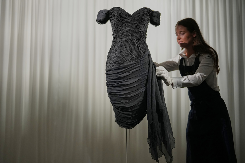 A dress worn by the late Princess Diana and known as the ''Revenge Dress'', designed by Christina Stambolian, is unveiled by staff at Sotheby’s auction house in London, Friday, Sept. 18, 2026, ahead of its Dec. 9 auction in New York, where it is estimated to sell for US$150,000-300,000. (AP Photo/Alastair Grant)