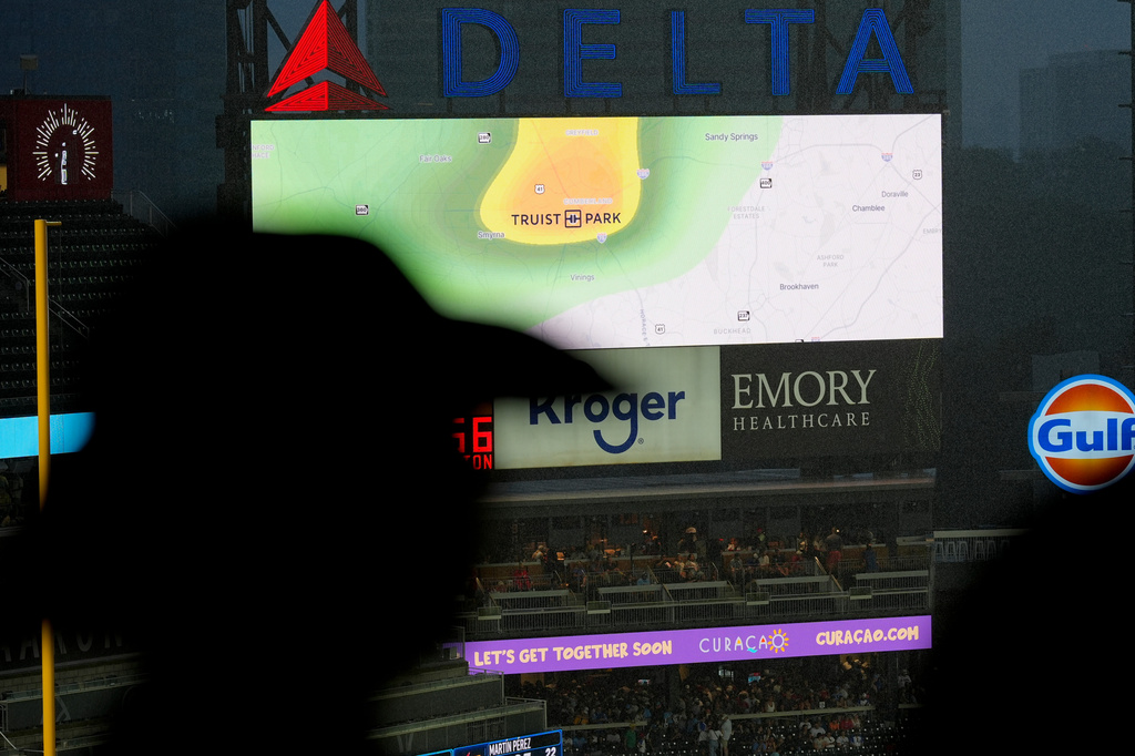 Spectators watch the field during a rain delay in the third inning of a baseball game between the Atlanta Braves and the Miami Marlins, Thursday, Aug. 6, 2026, in Atlanta. (AP Photo/Mike Stewart)