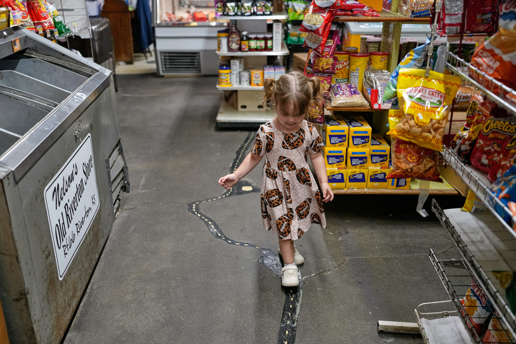 Oakley Wooten, 2, walks on a crack that formed inside the historic Nelson's Old Riverton Store about 20 years ago and was subsequently patched and painted to resemble Route 66 which passes by outside in Riverton, Kan., Tuesday, Nov. 18, 2025. (AP Photo/Jeff Roberson)