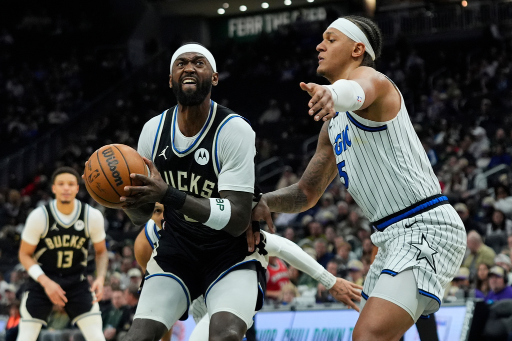 Milwaukee Bucks' Bobby Portis, left, looks to shoot against Orlando Magic's Paolo Banchero during the first half of an NBA basketball game, Sunday, March 8, 2026, in Milwaukee. (AP Photo/Aaron Gash)