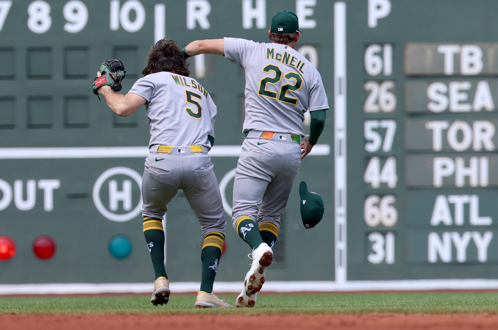 Athletics shortstop Jacob Wilson (5) catches a high fly ball while colliding with second baseman Jeff McNeil (22) during the second inning of a baseball game against the Boston Red Sox, Sunday, Aug. 9, 2026, in Boston. (AP Photo/Mark Stockwell)