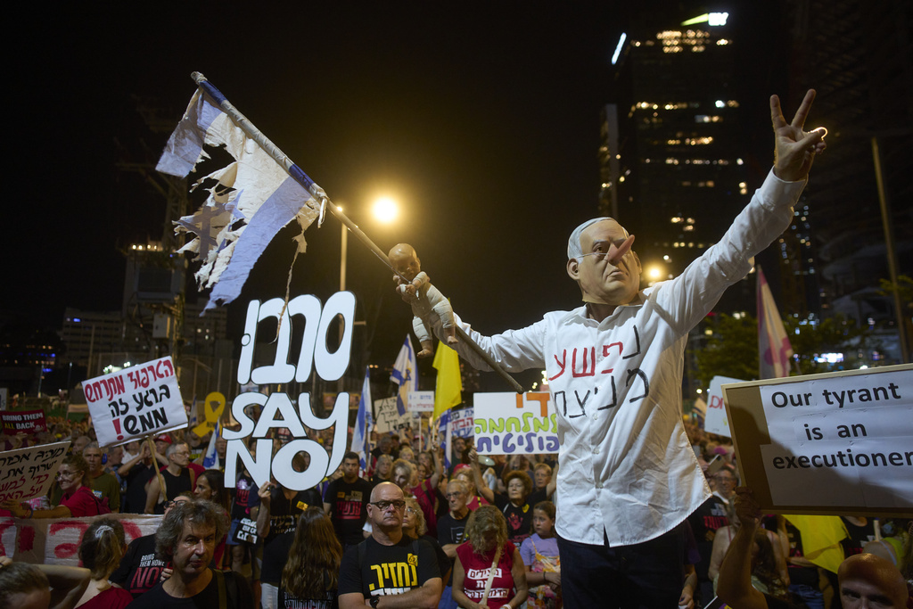A demonstrator takes part in a performance during a protest against Prime Minister Benjamin Netanyahu's government and calling for the release of hostages held in the Gaza Strip by the Hamas militant group, in Tel Aviv, Israel, Saturday, Aug. 23, 2025. (AP Photo/Ohad Zwigenberg)