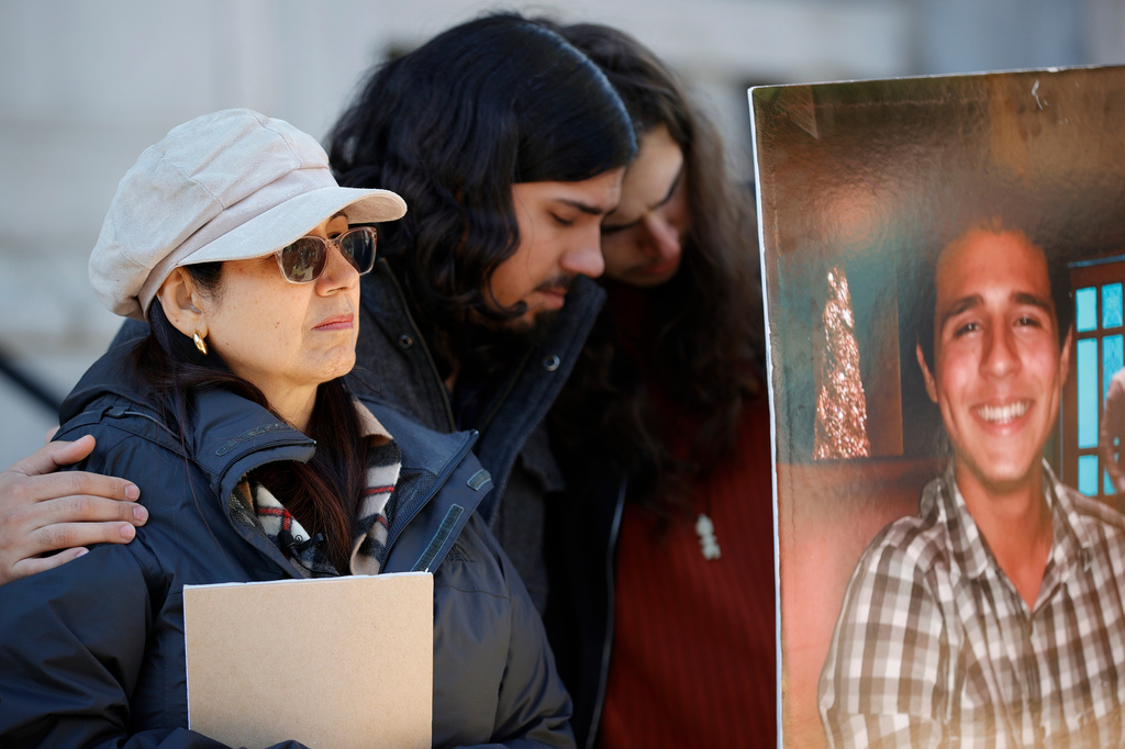 FILE - Belkis Terán, left, Daniel Paez, center, and Pedro Terán, family members of Manuel Esteban Paez Terán, known as “Tortuguita,” in poster at right, embrace during a news conference, Monday, March 13, 2023, in Decatur, Ga. (AP Photo/Alex Slitz, File)