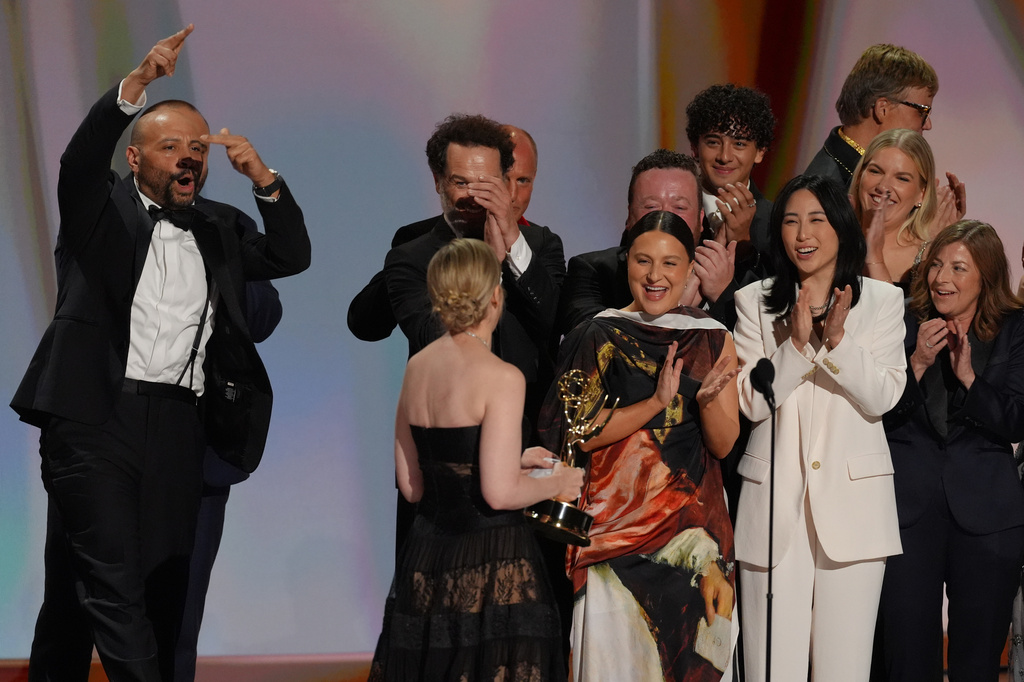 Katie Dippold, in front, and the team from "Widow's Bay" accept the award for outstanding comedy series during the 78th Emmy Awards on Monday, Sept. 14, 2026, at the Peacock Theater in Los Angeles. Woody Harrelson looks on from left. (AP Photo/Chris Pizzello)