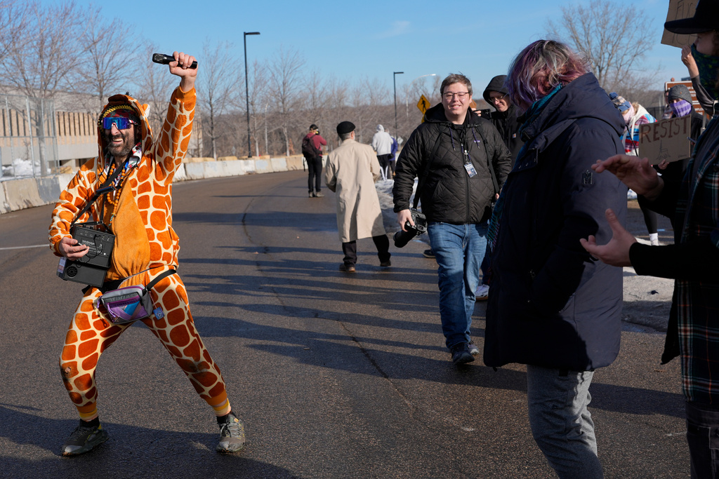 Rob Potylo, aka Robby Roadsteamer, wearing a giraffe costume he calls the "Jeffrey Epstein Giraffe", joins in a protest outside of the Bishop Whipple Federal Building, Monday, Jan. 12, 2026, in Minneapolis. (AP Photo/Jen Golbeck)