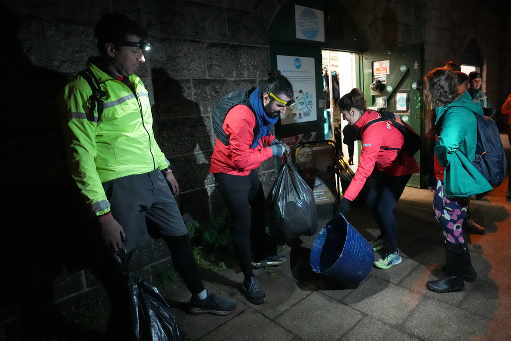 Participants in the Goodgym group collect litter from the riverbank to keep the River Thames free of plastic and other waste in London, Wednesday, Jan. 14, 2026. (AP Photo/Kirsty Wigglesworth)